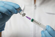 © New Africa - Doctor filling syringe with hepatitis vaccine from glass vial, closeup