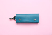 Stylish leather keys holder on pink background, top view