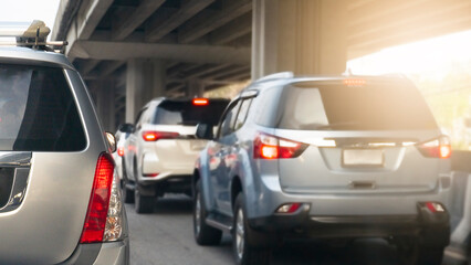 Wall Mural - Rear side of silver family car on the road with turn on brake light. under the concrete bridge. with other cars in the traffic jams during rush hour.