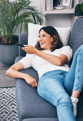 Sticker - Watching tv, relax and a woman on a sofa in the living room of her home streaming a subscription service. Television, channel surfing and comedy with an attractive young female lying in her lounge