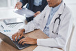 © C. D./peopleimages.com - Teamwork, research or doctors on laptop for medical review, data analysis or surgery feedback typing in hospital. Collaboration, paper or healthcare worker on tech for planning medicine strategy idea