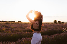 Woman Forming A Heart With Her Hands In A Lavender Field At Sunset