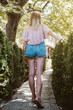 © Cavan Images - Back view of a blonde woman walking in a park in nature