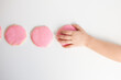 © Cavan Images - overhead view of child's hand taking pink frosted sugar cookie