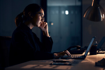 Serious woman, night business and laptop for planning, research and strategy in dark startup office. Female working overtime on computer technology, online website and network at table for analytics