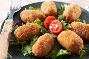 Canvas Print - Traditional spanish fried croquettes on wooden table. Close up