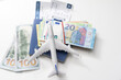 a miniature airplane , a passport case and euro money banknotes. selective focus. Travel concept