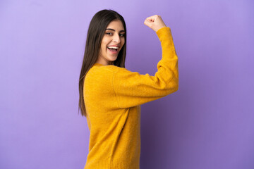 Wall Mural - Young caucasian woman isolated on purple background doing strong gesture