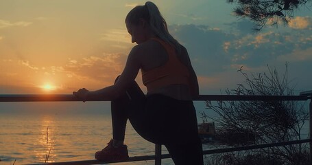 Wall Mural - Women are exercising in summer sunset with sea background. Warm-up, healthy running and outdoor exercise.