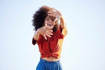 Woman, portrait and hands over face outdoor for fashion on a blue sky background with summer mockup space. Beauty model person with natural hair, happy smile and unique style for freedom mindset