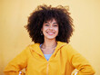 © Emily/peopleimages.com - Portrait, fashion and happy with an afro black woman in studio on a yellow background for style. Trendy, hair and smile with an attractive young female posing alone on product placement space