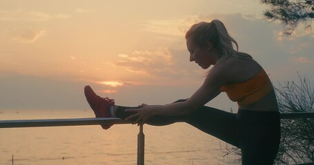 Wall Mural - Women are exercising in summer sunset with sea background. Warm-up, healthy running and outdoor exercise.