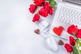 Fototapeta Kawa jest smaczna - Woman using her laptop with red roses. White laptop on white table background with chocolates, cookie hearts, red roses bouquet, flat lay working holiday, Valentine day background, top view copy space