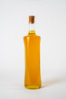 Olive oil in a glass bottle with a cork stopper isolated on white background.