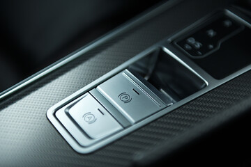 The driver's finger pulls the electric parking brake lever. electric parking rempl with auto hold mode in luxury cars