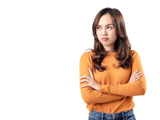 A portrait of an Asian Indonesian woman wearing an orange sweater and looking unhappy, folding her arms, isolated on a white background