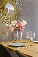 Wall Mural - Dining table in the kitchen with plates, utensils and big vase with flowers bouquet