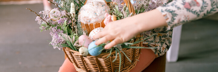 Wall Mural - happy easter holiday time in spring season. little eight year old kid girl holds basket with painted eggs and easter baked cakes. festive home decor. traditional food. banner