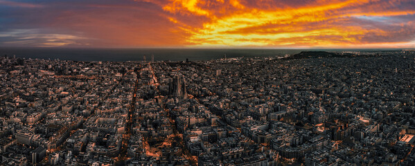 Fototapete - Aerial view of Barcelona City Skyline and Sagrada Familia Cathedral at sunset. Eixample residential famous urban grid. Cityscape with typical urban octagon blocks