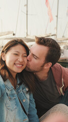 Loving couple kissing while sitting on the embankment