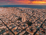 Fototapeta  - Aerial view of Barcelona City Skyline and Sagrada Familia Cathedral at sunset. Eixample residential famous urban grid. Cityscape with typical urban octagon blocks