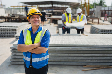 Wall Mural - Portrait Asia senior engineer man cross arm with team working with paper work and precast cement factory background