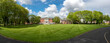 Panoramic view of Warrington Town Hall under a cloudy skyline and lush green garden in Warrington Cheshire, England.