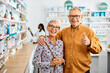 © Drazen - Happy senior man shows thumbs up while buying with his wife in pharmacy and looking at camera.