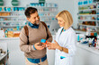 © Drazen - Happy man communicating with his pharmacist in pharmacy.