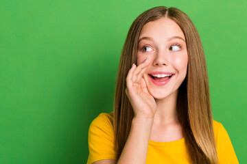 Poster - Closeup photo of young teen school girl hold palm cheek talking empty space secret announcement sale advert isolated on green color background