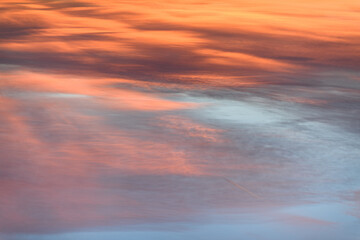 Wall Mural - Sky with soft and fluffy pastel orange pink and blue colored clouds. Sunset background. Nature. sunrise. Instagram toned style