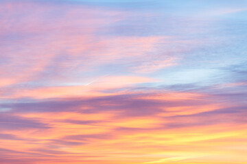 Wall Mural - Sky with soft and fluffy pastel orange pink and blue colored clouds. Sunset background. Nature. sunrise. Instagram toned style