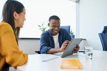 Young African businessman pitching new ideas to female coworker