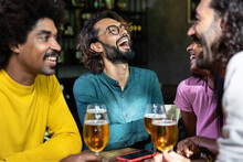 Young Group Of Happy People Drinking Cold Beer At Brewery Pub. Multiracial Colleagues Enjoying Happy Hours After Work Toasting Beer At Bar