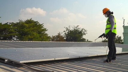 Wall Mural - Maintenance technician using cleaning mop and to clean the solar panels that are dirty with dust to improve the efficiency of solar energy storage.