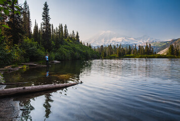 Wall Mural - A hiker standing on the log at Bench lake in front of Mount Raianier