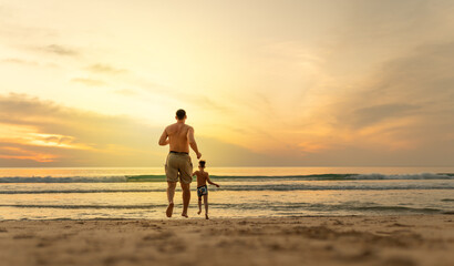 Father and son running on the beach 