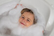 © Volodymyr - Kids face in foam. Child bathes in a bath with foam.