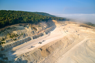 Wall Mural - Aerial view of open pit mining of limestone materials for construction industry with excavators and dump trucks