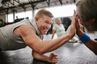 © Siphosethu F/peopleimages.com - Exercise, old men on floor and high five for achievement, fitness goals or happiness in gym. Mature male athletes, senior citizens or gesture for celebration, workout target or on ground for training