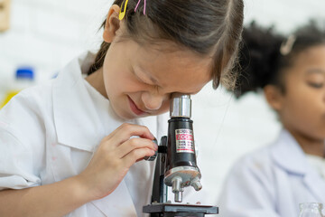 Lovely little girl scientist enjoy and excite to examine the color chemical in laboratory by using dropper with day light. Excited Kid celebrating over successful science experiment result or chemical