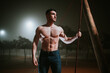 © Cavan Images - shirtless muscular man on the street on a foggy night
