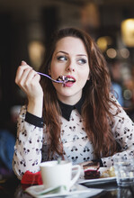 Portrait Of Young Woman Eating Cake