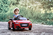© Cavan Images - A girl riding a toy car