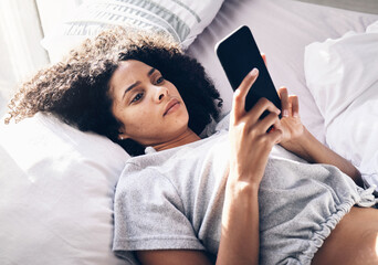 Wall Mural - Black woman, sad and typing with phone on bed in home bedroom for social media or internet browsing in the morning. Technology, bored and lonely female with mobile for web scrolling or networking.