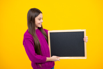 Poster - Teenage girl child holding blackboard, isolated on a yellow background.