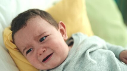 Sticker - Adorable hispanic baby lying on bed crying at bedroom