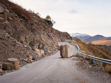 The Consequences Of An Earthquake On A Mountain Highway. Large Granite Boulder Fell On The Road. Dangerous Mountain Road After Earthquake. Dangerous Driving On A Mountain Road During A Rockfall.