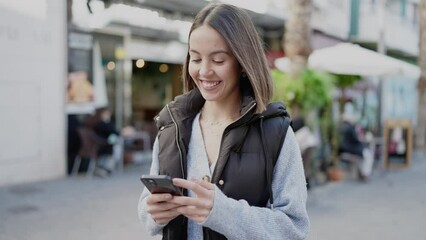 Canvas Print - Young beautiful hispanic woman smiling confident using smartphone at street