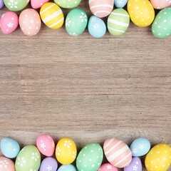 colorful pastel easter egg double border. above view on a square, light wood background. copy space.